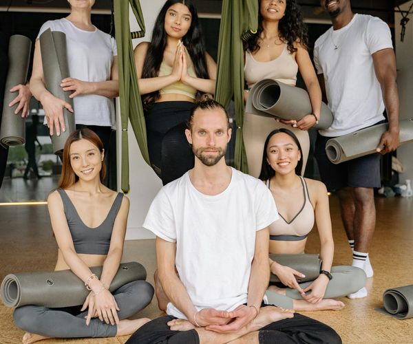 A diverse group of people smiling during a yoga class.